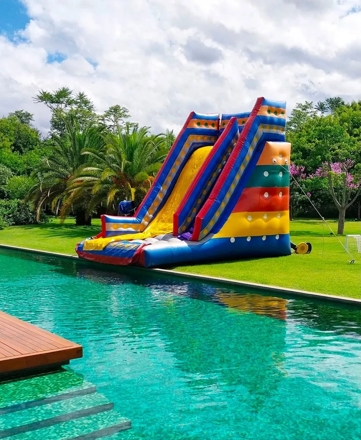 Tobogã colorido em um jardim ao lado da piscina